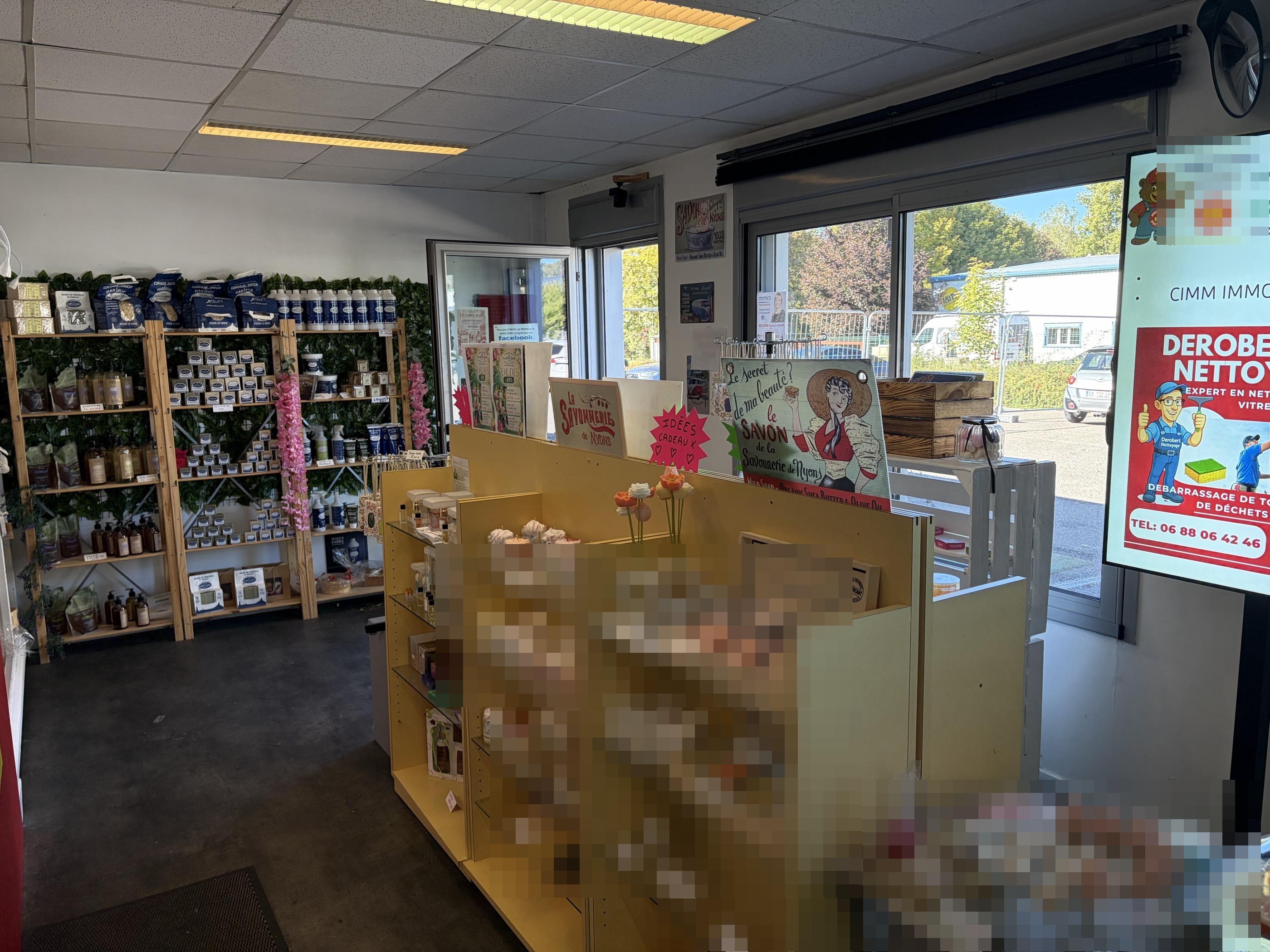 Intérieur de la boutique, étagères jaunes garnies de savons et de produits parfumés.