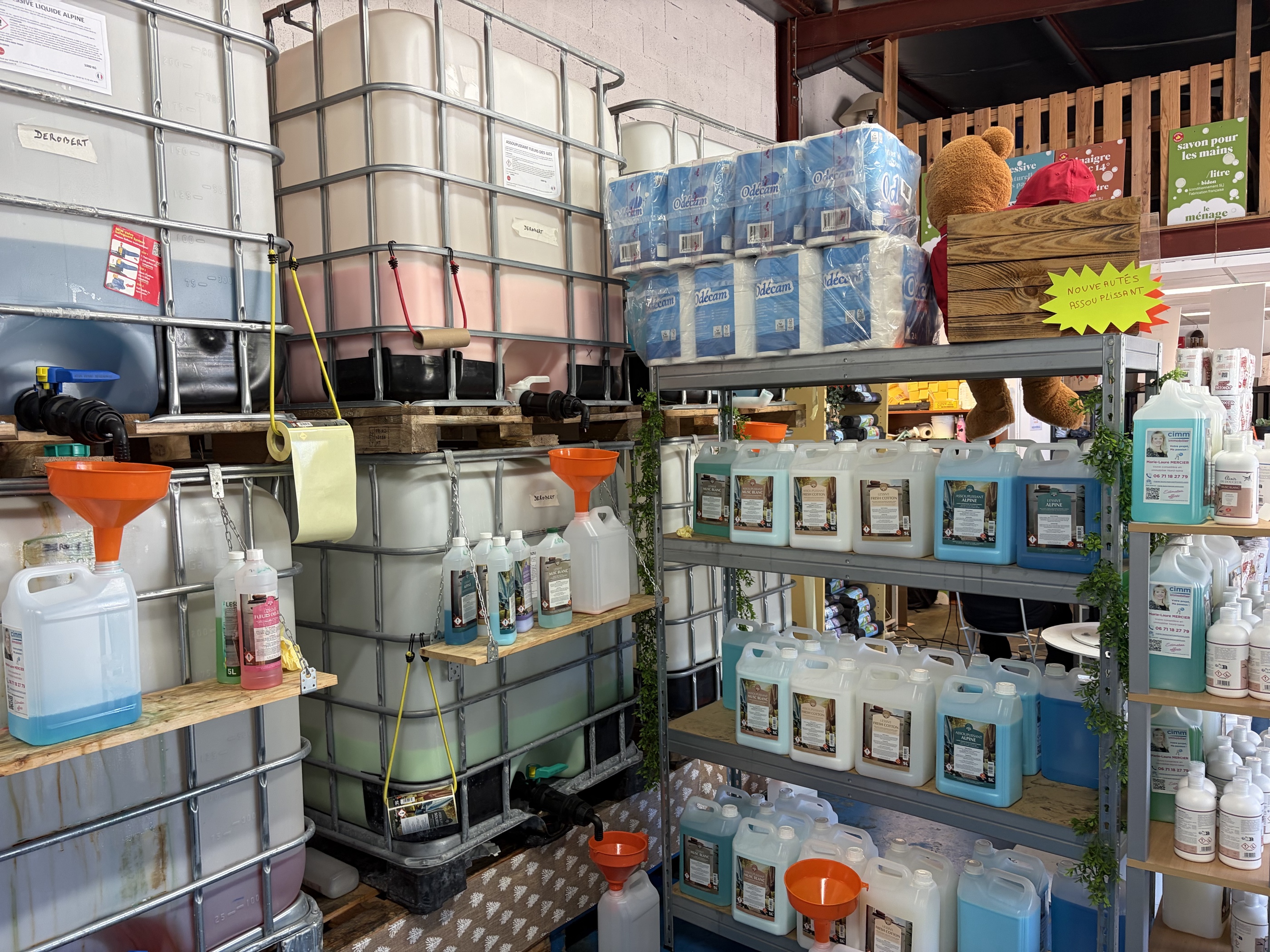 Cuves de 1000 litres sur palettes, entonnoirs orange et bidons de produits d’entretien.